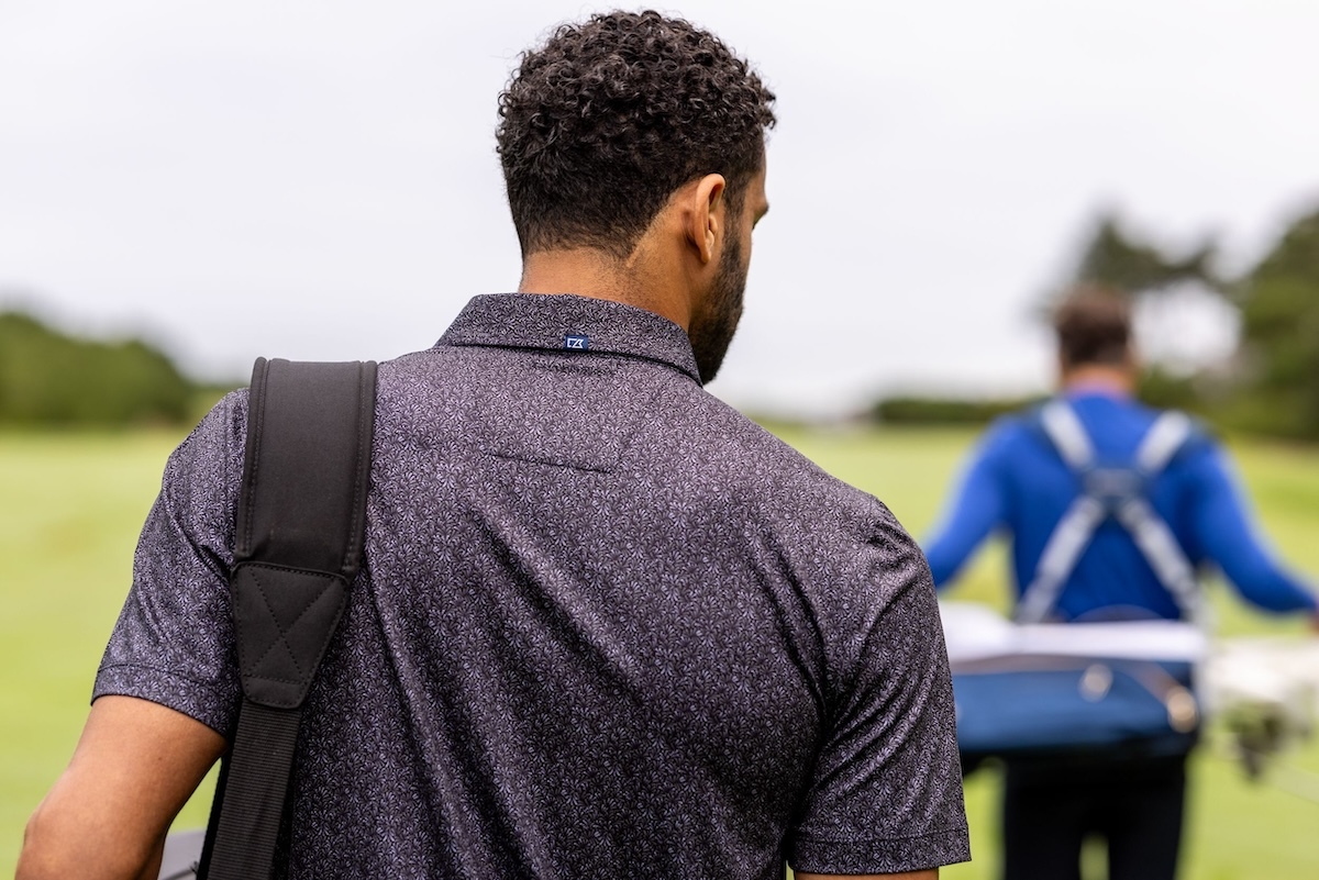 Back view of male golfer wearing a Pike Fern Print polo
