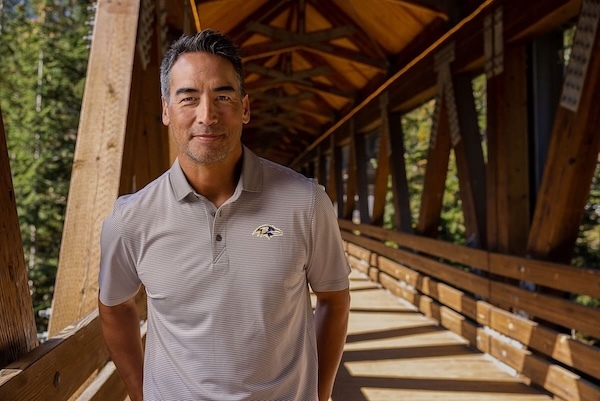 Man wearing Baltimore Ravens Cutter Buck Virtue Eco Pique Micro Stripe Recycled Mens Polo in Polished and White