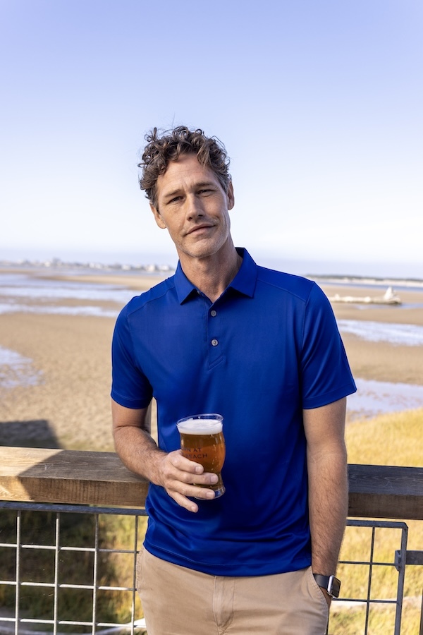 Man wearing a blue Cutter & Buck Virtue polo shirt