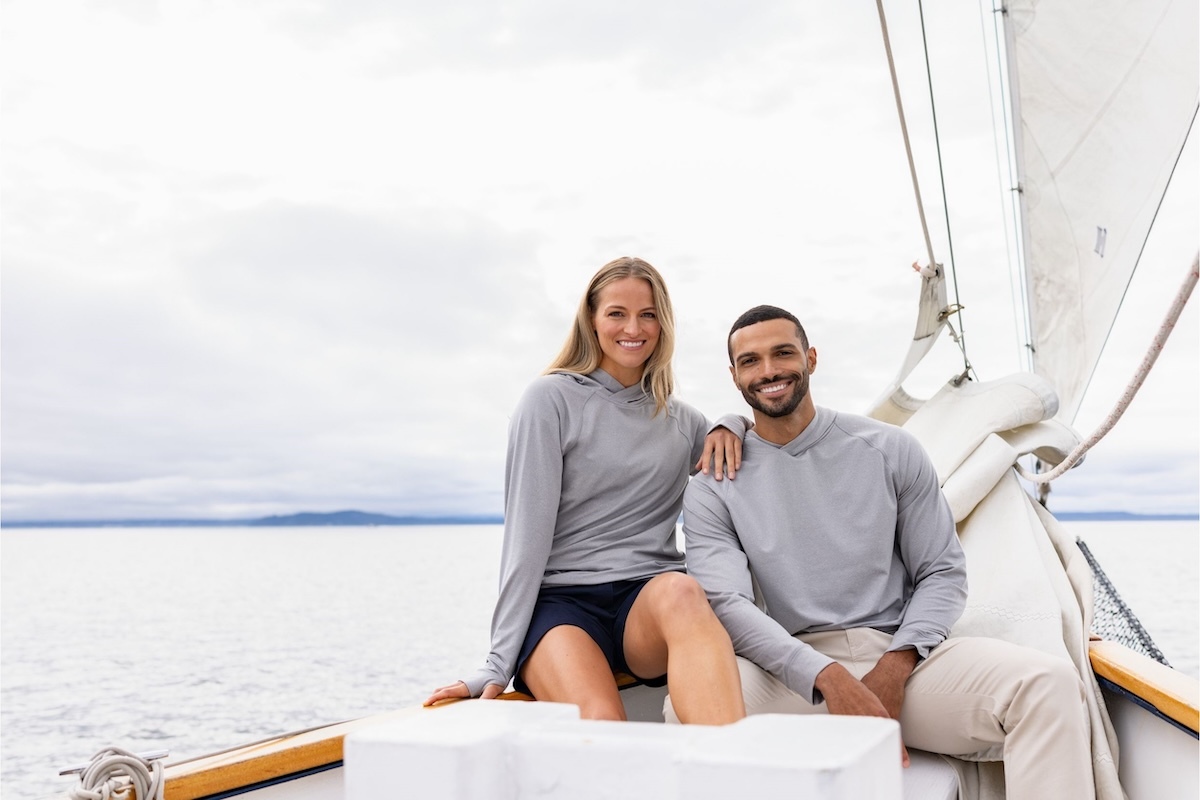 Man & woman on a boat wearing Adapt fleece hooded pullovers during fall