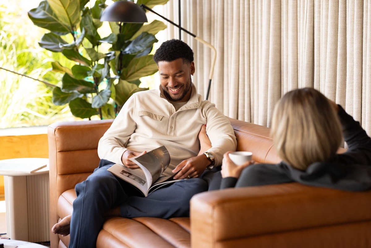 Man & woman conversing on couch while wearing Woodland snap fleece pullovers